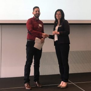 Second place winner Seth Tigchelaar (left) accepts a certificate from Michele Murphy.