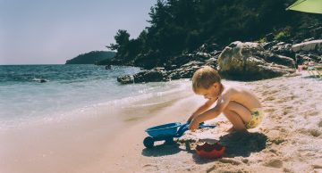 A toddler playing at the beach. Photo by Dragos Gontariu.