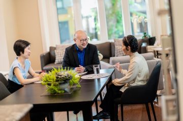 Dr. Roger Wong (middle), a UBC clinical professor of geriatric medicine who helped inform the report, speaks with one of his patients and their daughter.