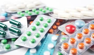Blister packs of colourful medicine pills on a surface.