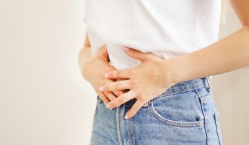 A person holding their stomach, suggesting discomfort